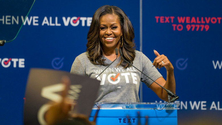 Michelle Obama speaking at podium smiling