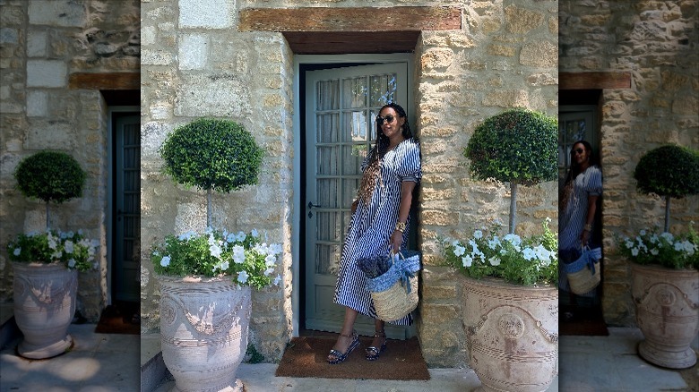 Tia Mowry posing for a picture in front of a stone building