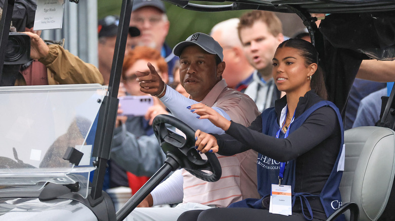 Sam Woods driving her dad in a golf cart