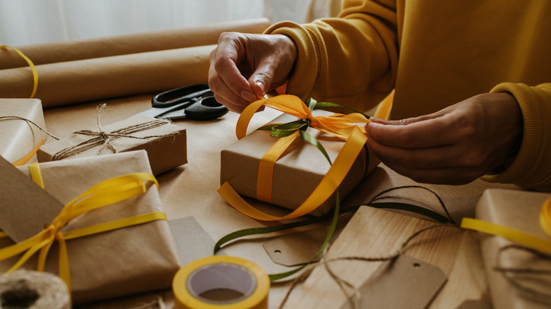 Woman putting a bow on a present