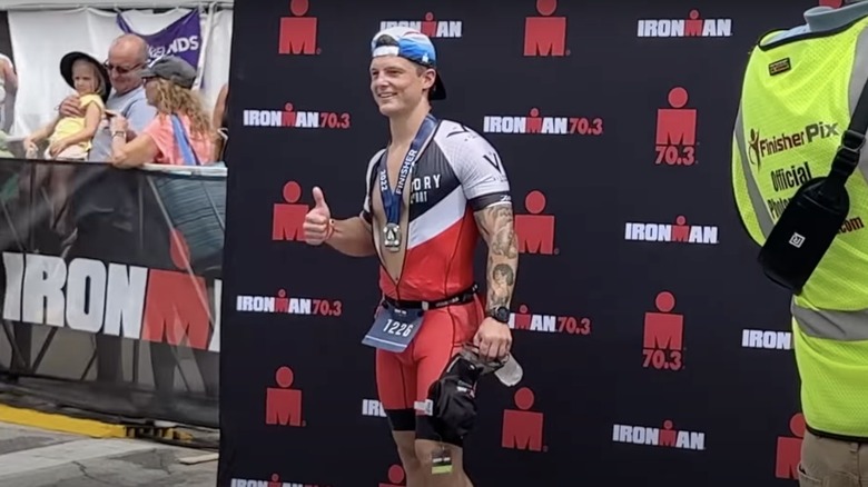 Josh Herbert posing after completing the Ironman Triathlon