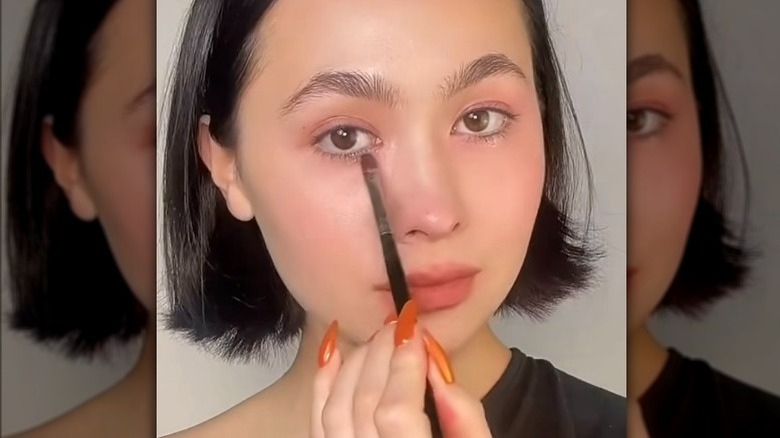 Closeup of Zoe Kim Kenealy applying makeup