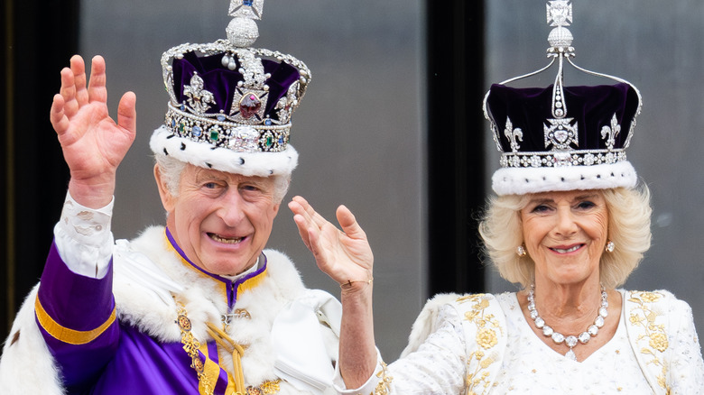 King Charles and Queen Camilla waving in crowns