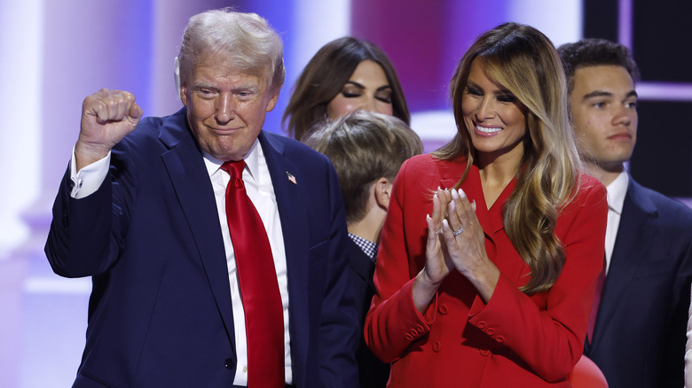 Donald Trump holding up fist while Melania Trump smiles