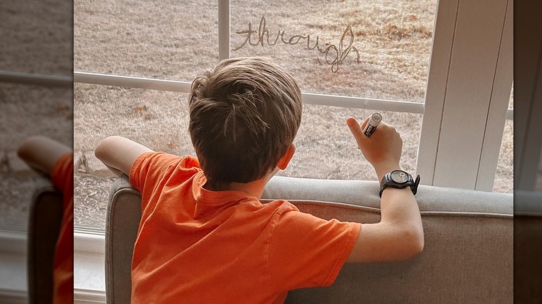 Israel Dillard writing on window