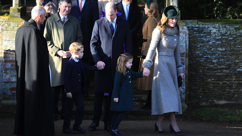 The Prince and Princess of Wales walking with their children 