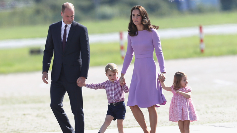 The Prince and Princess of Wales walking with their children 