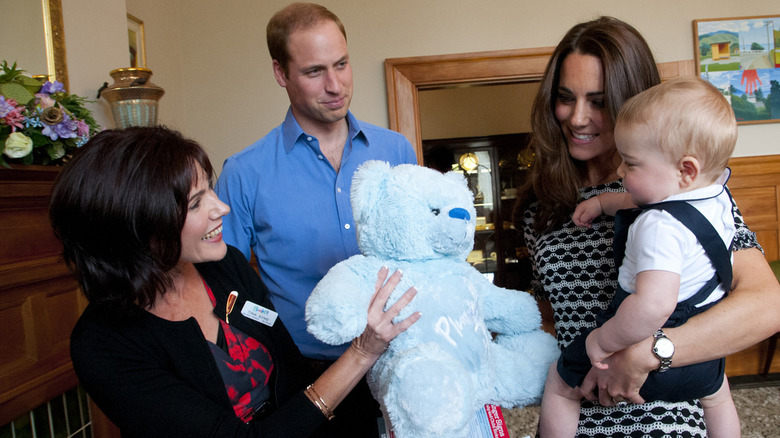 The Wales family looking at teddy bear 