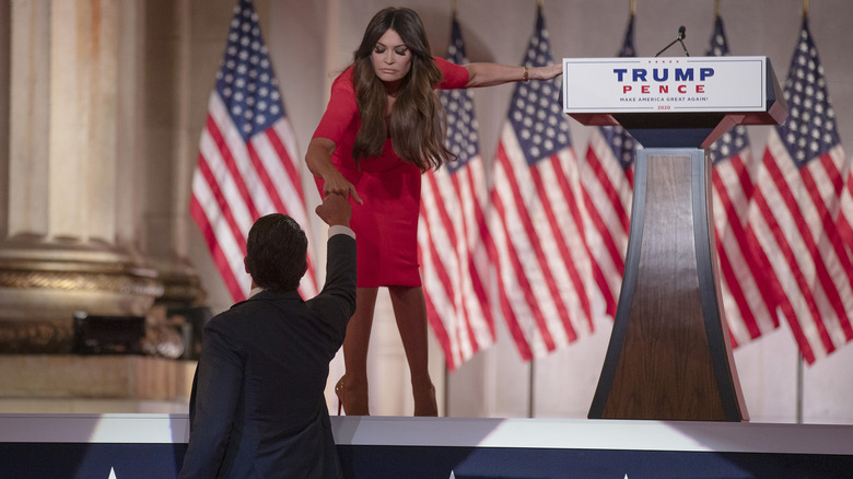 Kimberly Guilfoyle fist bump Donald Trump Jr. while holding podium