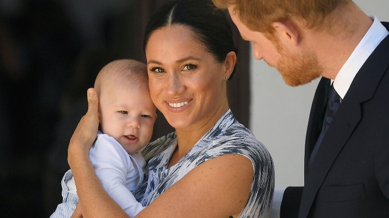 Meghan smiling and holding Prince Archie