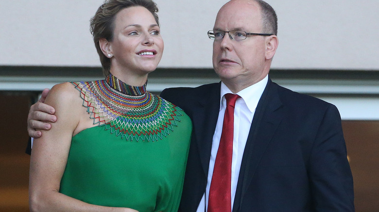 Princess Charlene receiving embrace from Prince Albert