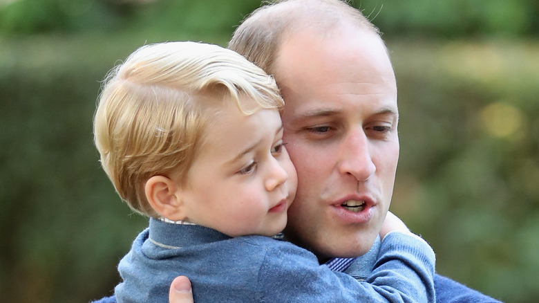 Prince William carrying Prince George