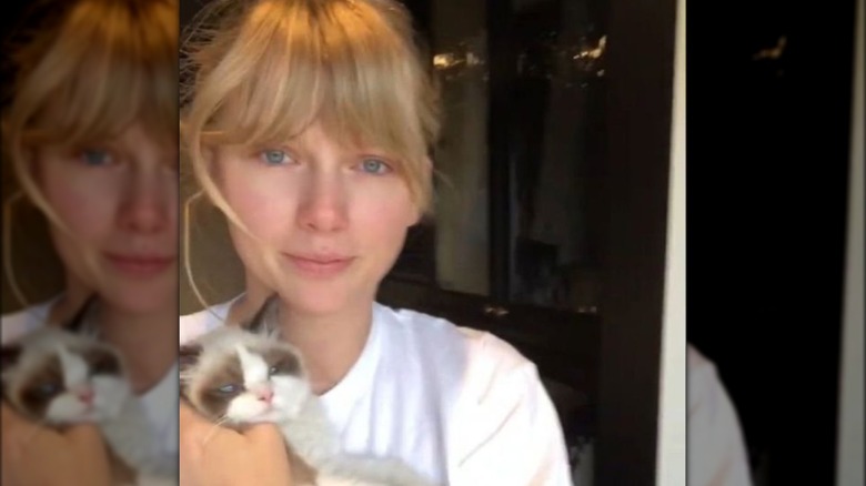 Taylor Swift smiling, holding Benjamin Button Swift