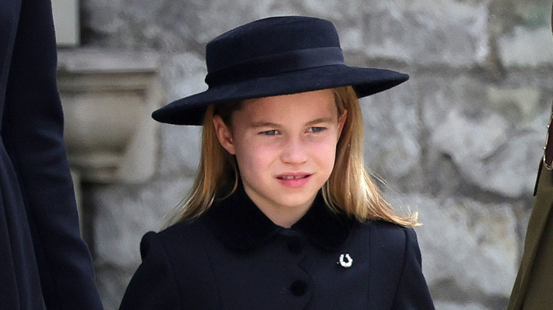 Princess Charlotte looking somber in her black coat and hat for Queen Elizabeth's funeral