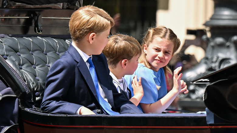 Prince George watching Prince Louis and Princess Charlotte waving