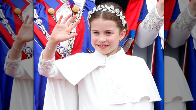 Princess Charlotte smiling and waving in her coronation outfit