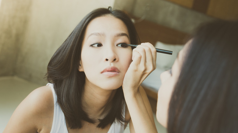 woman applying eyeliner