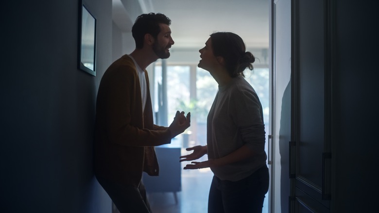 Couple arguing in a doorway