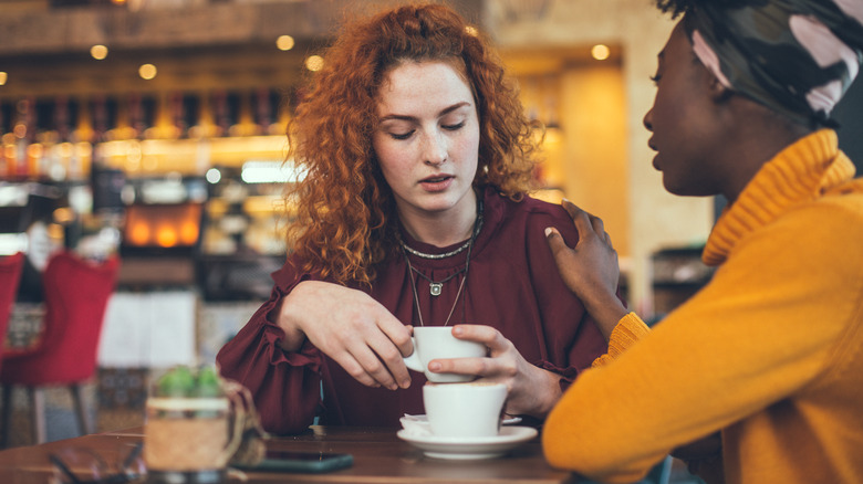 woman putting comforting hand on friend