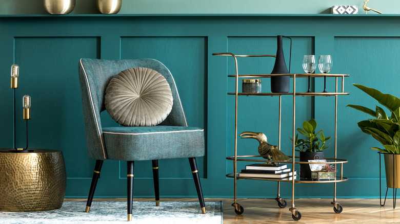 Teal-painted sitting area with gold accents