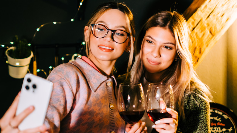 women taking selfie with wine