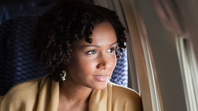 woman looking out plane window