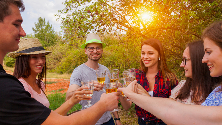 smiling friends drinking outside