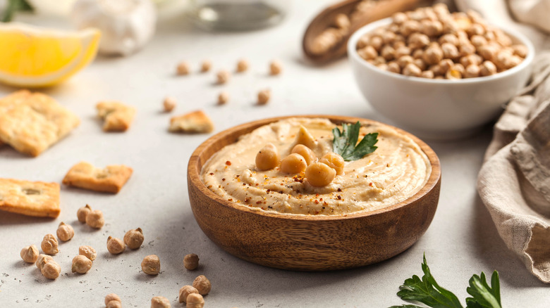 Hummus and chickpeas in a wooden bowl