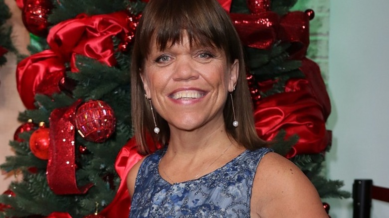 Amy Roloff smiling in front of Christmas tree