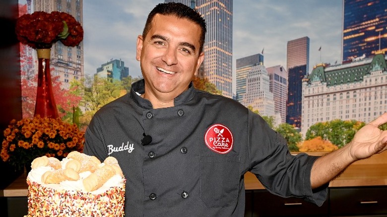 Buddy Valastro in chef's uniform holding cake