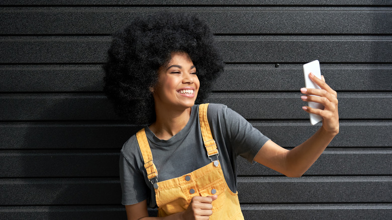 A photo-ready woman takes a selfie