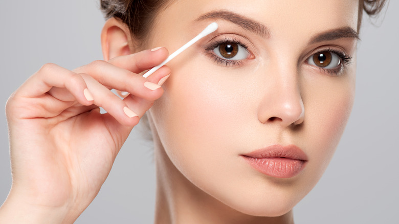 Woman using cotton swab 