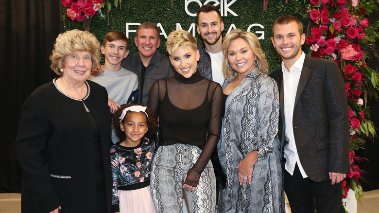 The Chrisley family pose in front of a rose backdrop