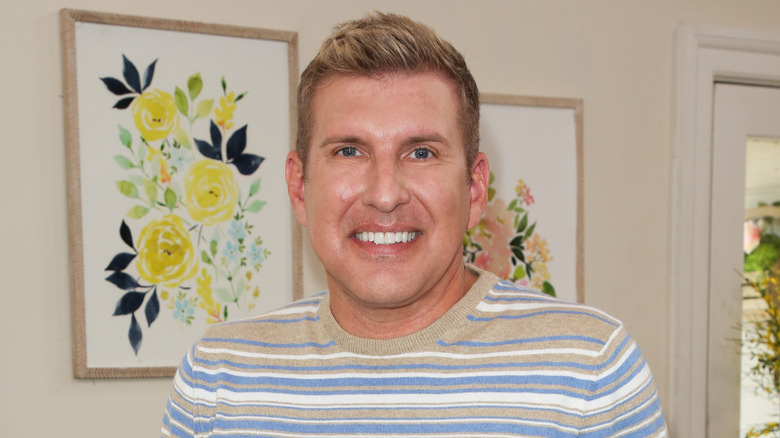 Todd Chrisley smiles while wearing a striped sweater