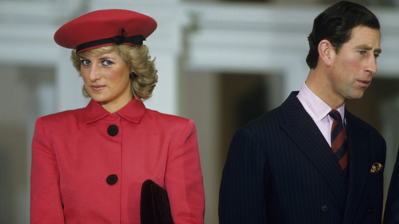 Princess Diana in red beret Prince Charles looking to side