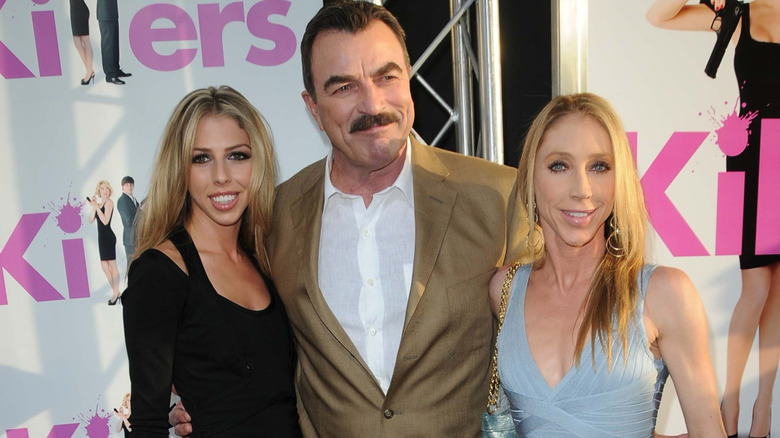 Hannah Selleck, Tom Selleck, and Jillie Mack stand close on the red carpet