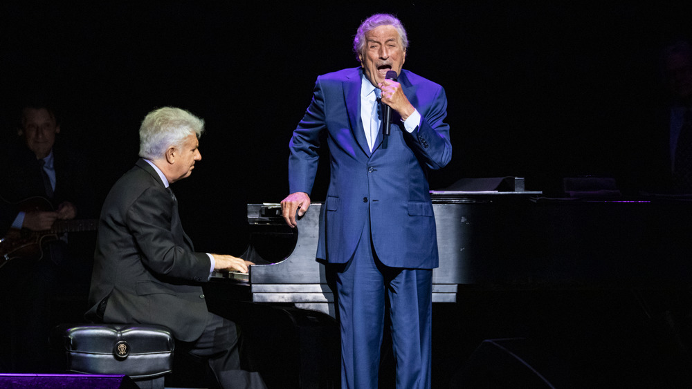 Tony Bennett singing in front of a piano