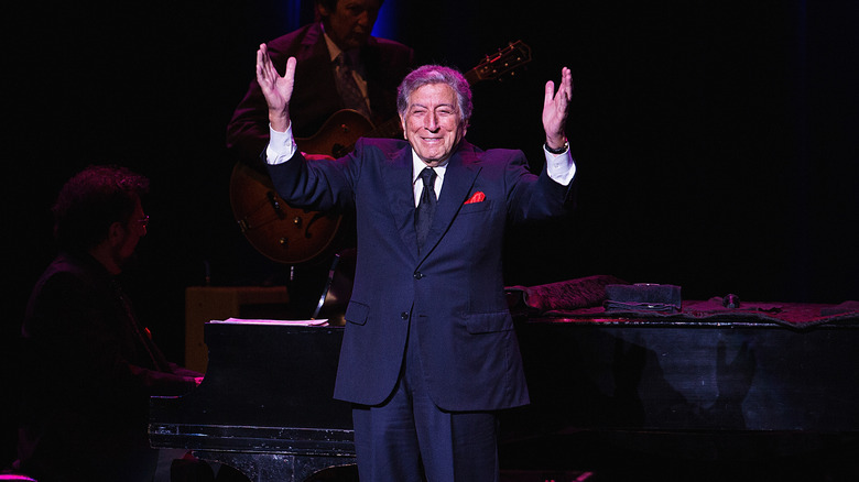 Tony Bennett performing hands raised