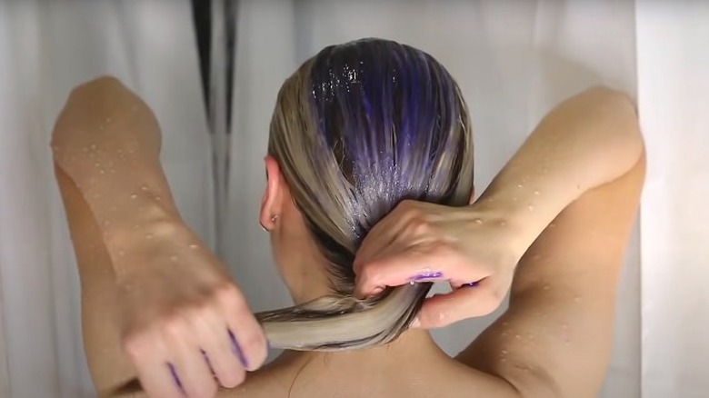 woman washing hair with purple shampoo