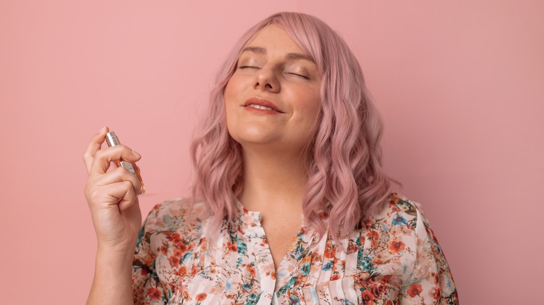 A woman applying perfume