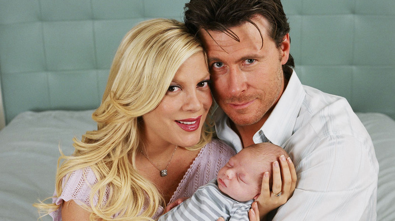 Tori Spelling and Dean McDermott holding their baby 