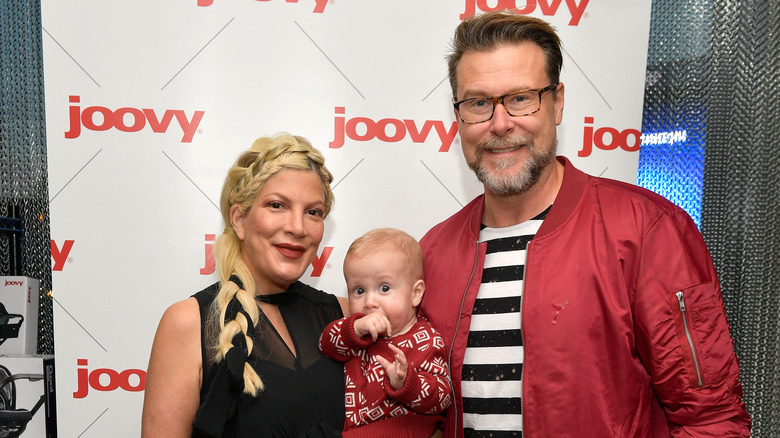 Tori Spelling and Dean McDermott posing with their son