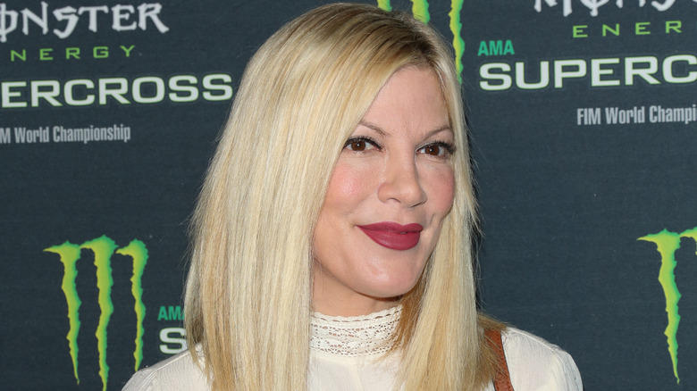 Tori Spelling smiling at an event in 2016