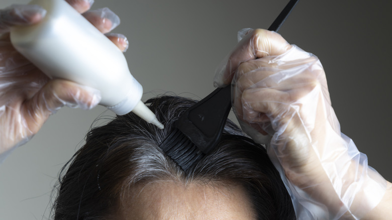 Woman touching up her gray roots