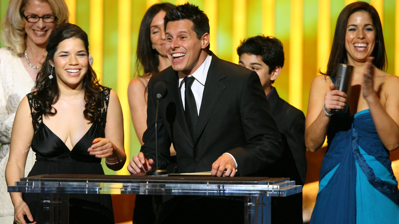 America Ferrera on stage smiling with the "Ugly Betty" cast 