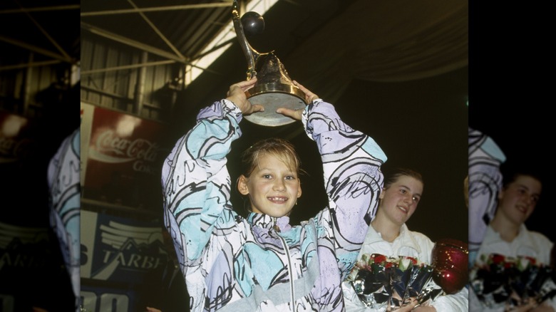 Young Anna Kournikova holding up trophy