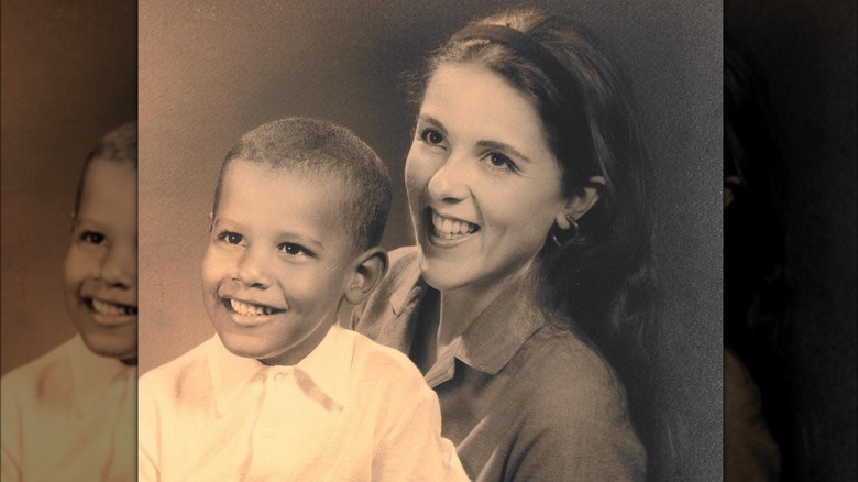 Barack Obama smiling while his mom, Ann Dunham, holds him