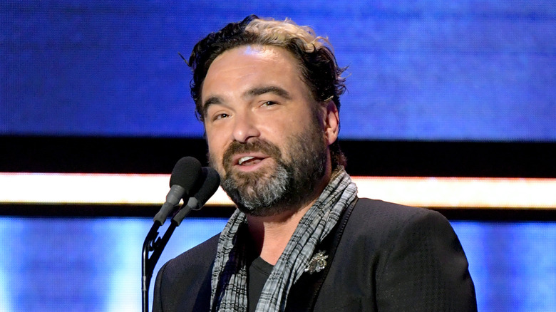 Johnny Galecki standing at a microphone