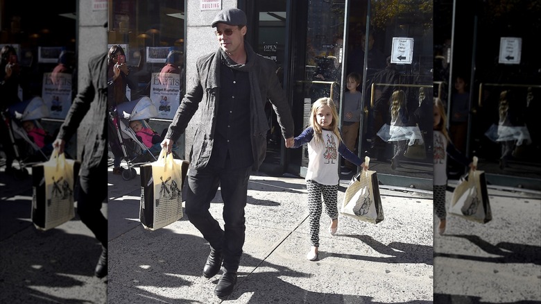 Brad Pitt and young Vivienne Jolie-Pitt walking holding hands