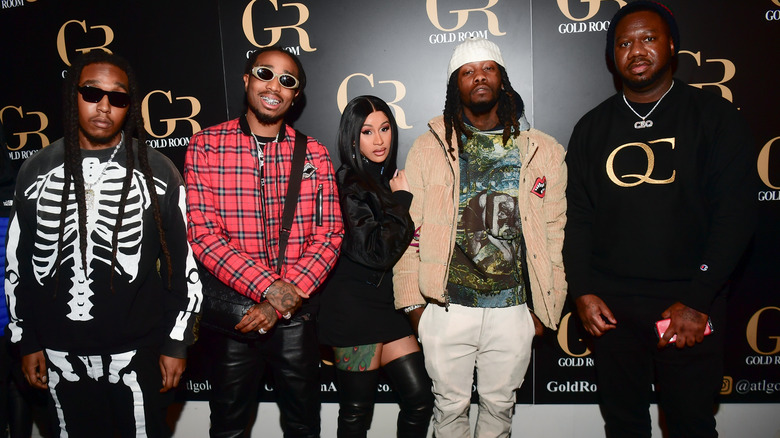 Cardi B posing with Migos 